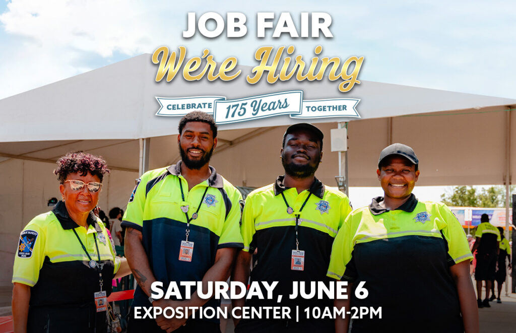 Four smiling staff in neon uniforms stand in front of a job fair tent; banner reads 'Job Fair We're Hiring' with date and venue details.